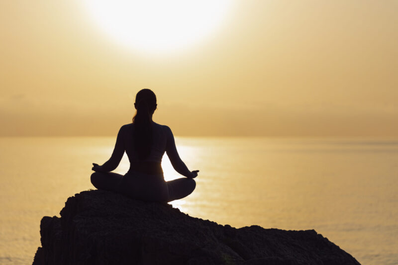 Serenity and yoga practicing at sunset, meditation. silhouette on sea background with sunrise Hatha Yoga Sun